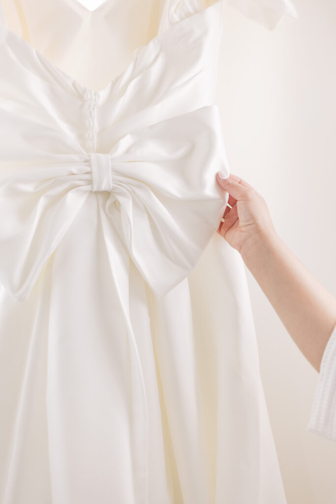 Bride holding the bow on her wedding dress. Tuscan Rose Ranch