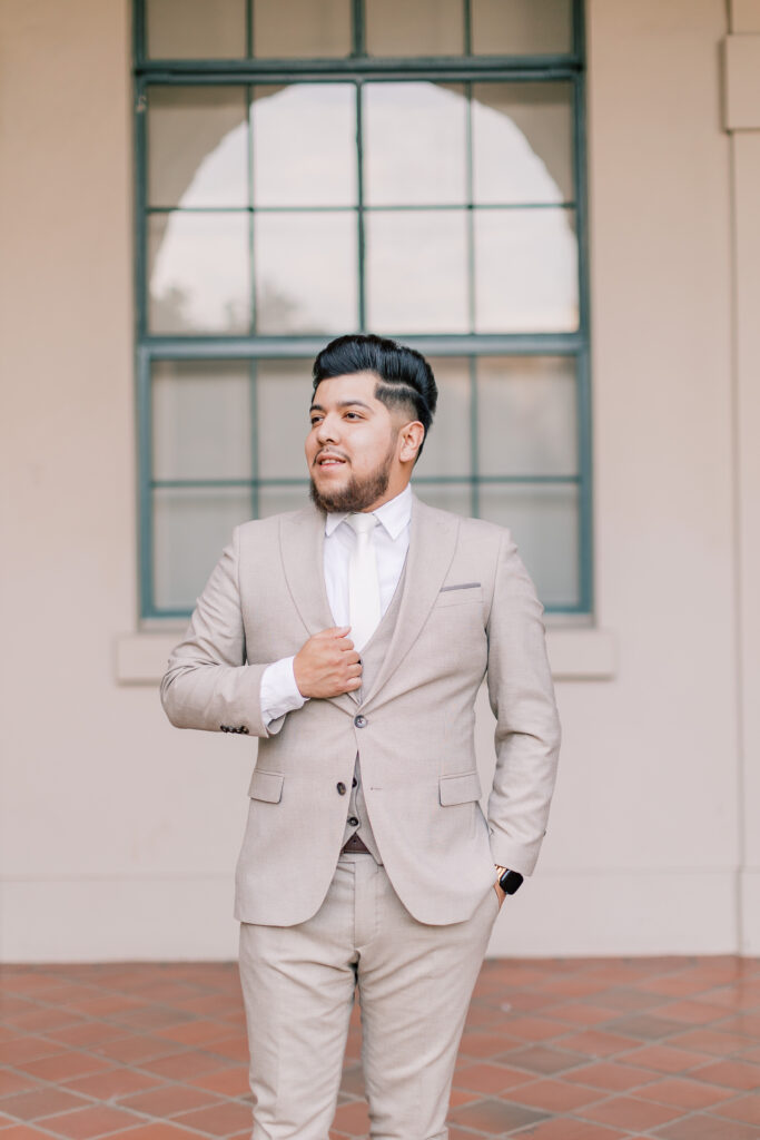 Groom looking to his right, standing under an arch