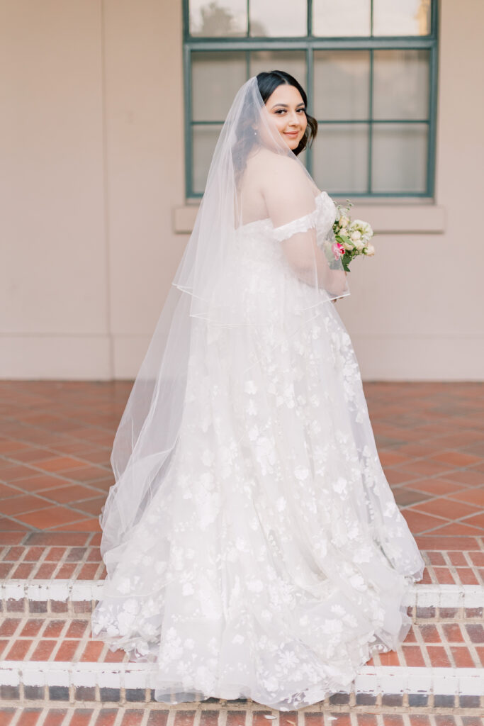 bride standing under an arch