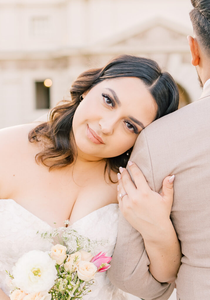 Closeup of bride's facfe resting on groom's shoulder