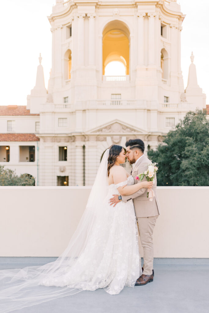 Bride and groom embracing in behind Pasadena City Hall