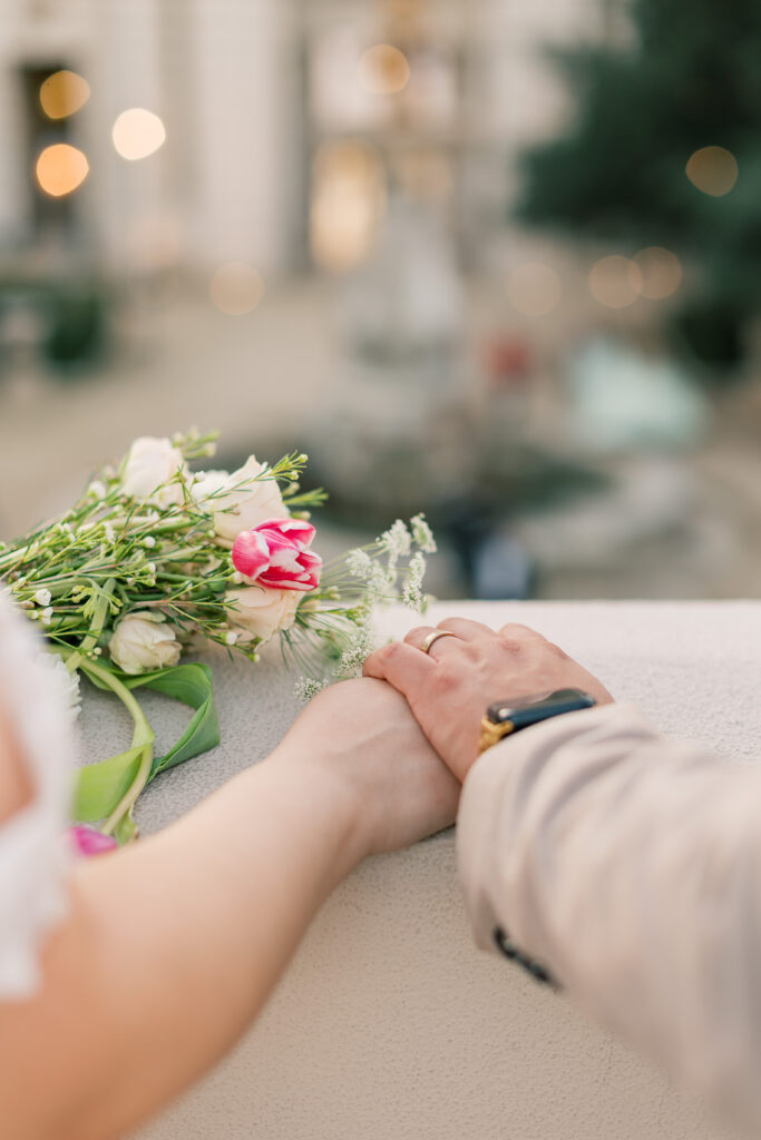 groom holding his wife's hand overlooking the balcony at Pasadena City Hall