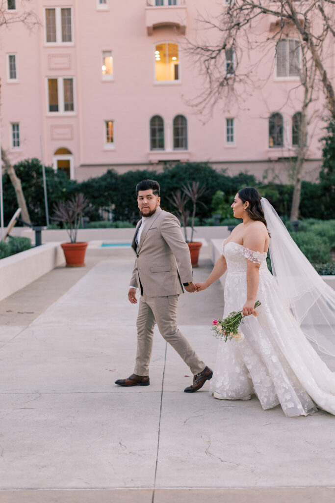 Couple walking in front pink building