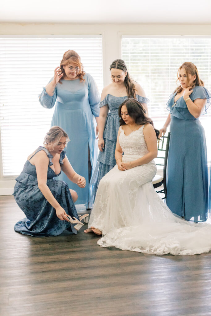 bride sitting in a chair, surrounded by bridesmaids