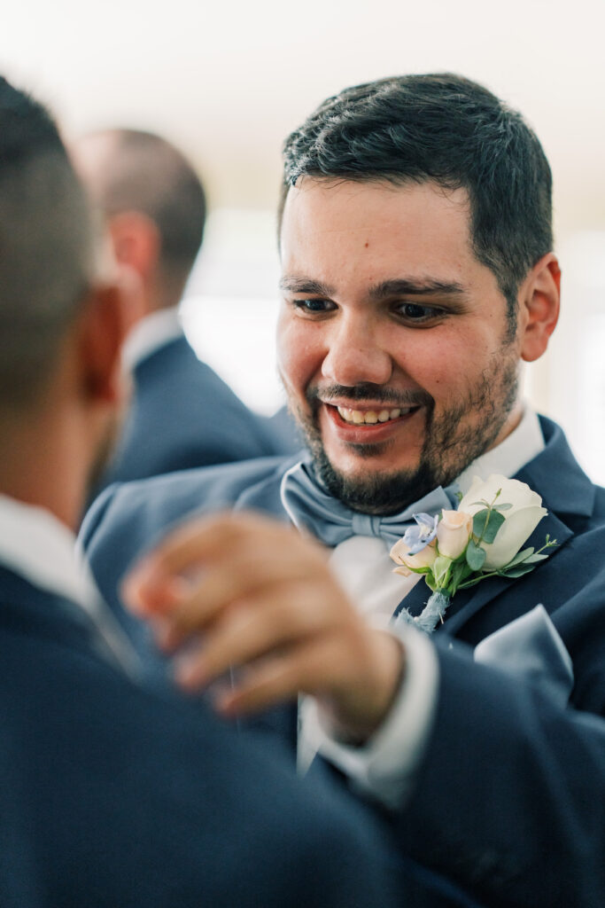 Groom adjusting his groomsmen's tie