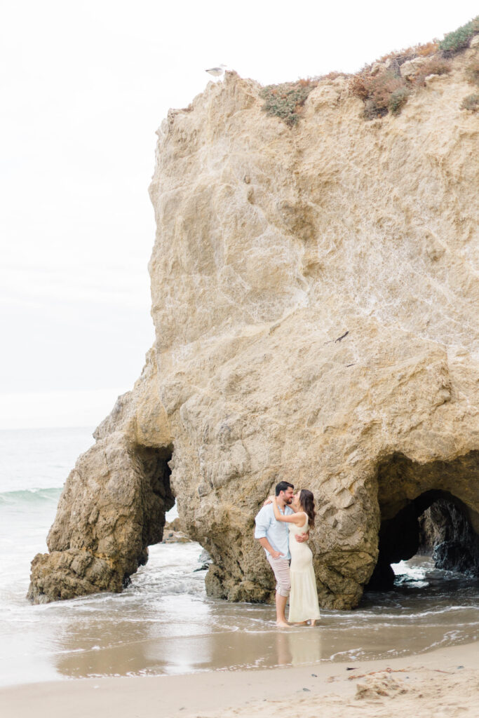 a couple in front of a boulder at El Matador State Beach